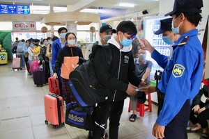 乘客走進東區車站上車前接受體溫測量。