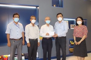 守德市委民運處副主任李黃南（右二）向華人老革命陳健智（右三）贈送禮物。