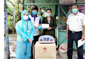 在疫情複雜多變的背景下，許多黨員在黨和人民前體現了其先鋒責任。圖中：陳文欣黨員（右）向守德市鈴中坊貧困居民贈送禮物。