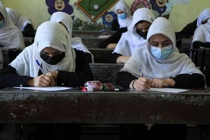 阿富汗女學生坐在校園裡上課。（圖源：互聯網）