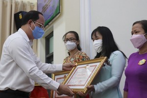 市委副書記阮胡海為2016-2020年階段“全民團結建設新農村與文明都市”運動取得傑出成績的集體與個人頒贈獎狀。