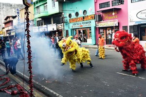 圖為 2015年2月19日，巴拿馬華人社區成員在巴拿馬市街頭上進行放鞭炮舞獅表演慶祝農曆新年。（圖源：AFP）