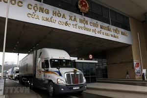 各輛農產品集裝箱車在金城2號口岸等待辦理出口中國的手續。