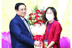 政府總理范明政向模範教師代表送花祝賀。（圖源：越通社）