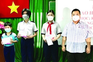 丁文森先生向貧困學生贈送助學金。