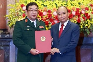 國家主席阮春福（右）向國防部副部長范懷南中將頒授晉升上將軍銜《決定》。（圖源：越通社）