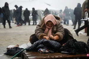 圖為一名婦女在白羅斯和波蘭邊境附近地區洗衣服。（圖源：路透社）