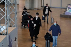 旅客28日抵達以色列特拉維夫近郊的班古里昂機場。以色列宣佈禁止所有外國人入境，本國人返國也必須隔離。（圖源：AFP）