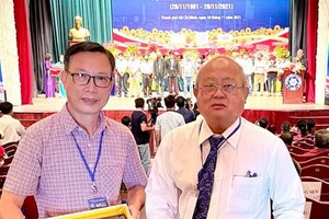 華人攝影家陳文儀及華人攝影會會長許勵程(右)領取紀念章。