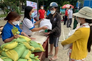 當地民眾積極響應“垃圾換取大米”活動，一大早就紛紛把一袋袋垃圾送到回收點換取大米後，興高采烈地抱著一包包大米回家。（圖：友真）