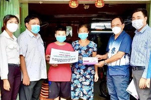 麥漢強先生(右二)與地方政府代表向第六郡第三坊孤兒贈送生活費。