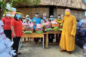 蓮華寺住持釋惟鎮法師（右一）向貧困少數民族同胞派發救濟品。
