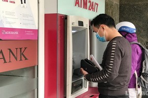 民眾在櫃員機提款。（圖：勞動報）