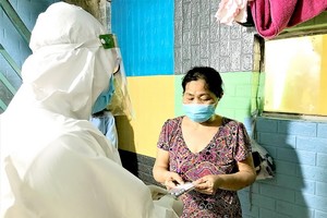 平盛郡第十一坊醫療站人員給居家治療新冠患者看診和派發藥物。