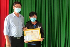 廣義省李山島縣人委會代表向陳英勇船長（右）頒發獎狀。（圖：阮莊）