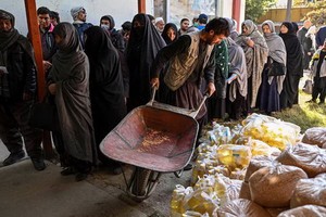 2021年11月6日，人們在阿富汗喀布爾舉行的世界糧食計劃署食品分發活動中排隊等候領取糧食。（圖：AFP）