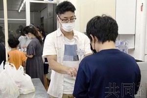 圖為NPO職員（左二）向貧困家庭子女發放食物。 9月攝於茨城縣筑波市。（圖：共同社）