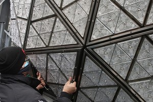 工作人員正在為水晶球安裝的三角形水晶玻璃片。（圖：互聯網）