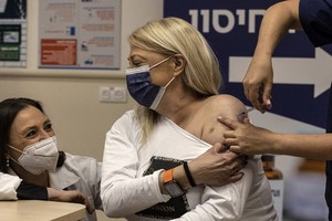 一名以色列婦人12月31日接種第4劑輝瑞新冠疫苗。（圖：AP）