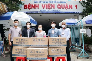 市越南祖國陣線委員會和越英長大興國際藥品股份公司代表向第一郡醫院移交援助新冠確診者的藥物。