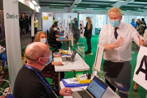 英首相約翰遜(右)前往新冠疫苗接種中心視察。（圖：路透社）
