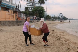 當地居民在富國島海灘撿拾塑料垃圾，美化環境。（圖：國平）