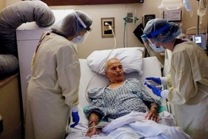 圖為在美國俄亥俄州一家醫院的隔離醫療單元樓層的房間，醫務人員上週三在治療新冠肺炎患者的檔案照。（圖：路透社）