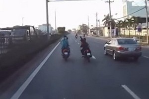 一輛汽車的行車監控錄取了兩輛摩托車上的人員手持利器在路上互相追砍的畫面。