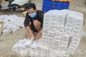 被抓獲的走私香煙歹徒及證物。（圖：越通社）