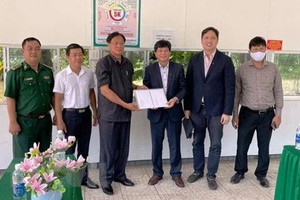 堅江省外務廳長文公鬥（左三）通過越南駐柬埔寨西哈努克省領事館代表向居柬越僑貧困同胞贈送3億元。（圖：越通社）