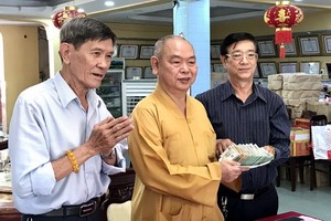 龍華寺護法會會長鄧栢榮(右)向釋慧功和尚移交善款。