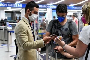 意大利米蘭，工作人員在機場檢查乘客的綠色通行證。（圖：互聯網）