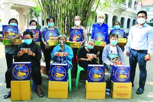 本報編委文忠孝(右)向華人貧困同胞贈送禮物。