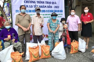 紅十字會領導與丁文森先生向清寒人家發送新春禮物。