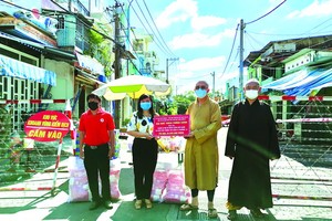 釋通振法師向第八郡第十二坊領導轉贈物資予封鎖區居民。