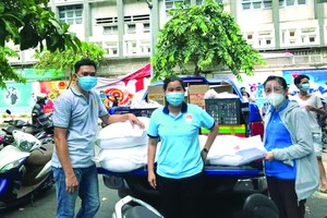 黃錦樑(左)將糧食運送到隔離區。