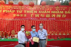 本報編委文忠孝（左）向海南會館理事長吳清華先生贈送紀念章，感謝會館5年來為慈善揮春活動熱情提供場地。