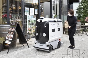 店員將便當裝入機器人的儲物箱內。（圖：共同社）