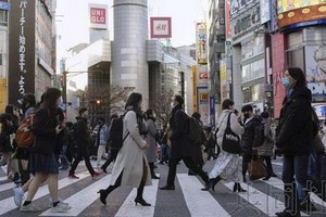 為減輕醫療負擔，日本政府允許年輕人不就診居家療養。圖為東京街頭一景。（圖：共同社）