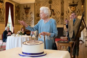 英國女王伊麗莎白二世5日在桑德令罕府切蛋糕。（圖：AFP）