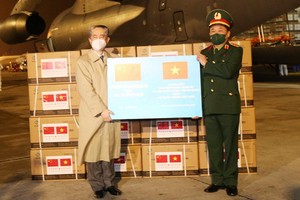 中國駐越特命全權大使熊波（左）向越南國防部移交30萬劑新冠疫苗。（圖：越通社）