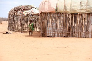 圖為 8月26日，一名兒童走在遭受旱災的肯尼亞馬薩比特郡萊薩米斯鎮一干旱的村莊內。（圖：新華社）