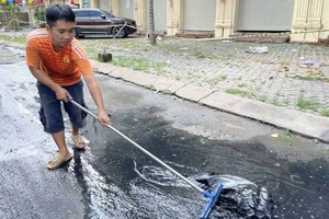 家住新泰和坊的阮成心於今年10月24日上午清理街道上的髒水。