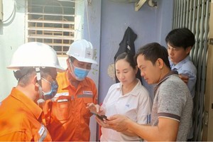 電力公司人員指引民眾使用電力公司應用查詢資訊。