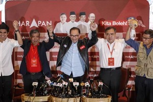 馬來西亞在野黨希望聯盟在這次大選贏得最多席次，領導人安瓦爾（中）與該黨高層廿日在吉隆坡總部振臂慶功。（圖：歐新社）