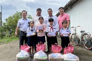 頭頓崇正天后宮理事長鄒國榮（左一）與常值副理事長梁志偉（右一）與地方領導向學生贈送禮物。