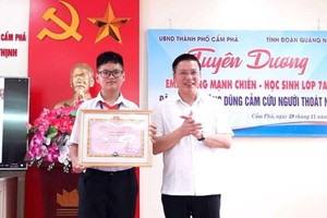 奮勇救人的初中生黃孟戰（左）獲表彰。（圖：錦譜市報）