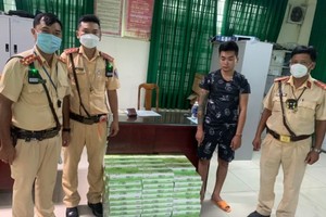 被查獲的走私香煙和被扣留的走私者（右二）。（圖：PC08）