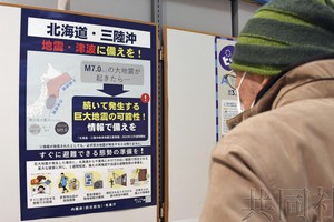 一位老爺在觀看後發地震警惕的疏散避難圖。（圖：共同社）