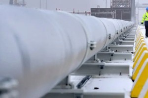 2022年12月17日，一名工人走過連接浮式氣化儲存裝置船與德國北部威廉港主要陸地的煤氣管道。（圖：AFP）